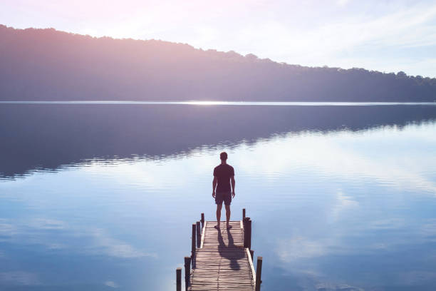 Person looking over the ocean reflecting on living with purpose and discovering life’s meaning
