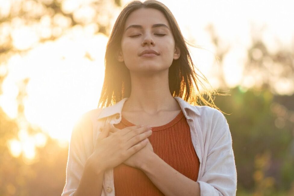 Person practicing grounding techniques such as deep breathing to calm anxiety and reduce emotional overwhelm.