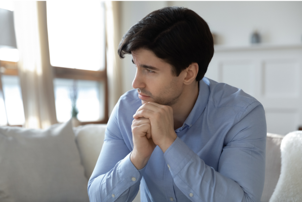 Person sitting quietly in reflection, representing feelings of depression and loss of meaning.