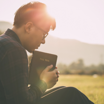 Person praying and reflecting with a journal while seeking emotional healing.